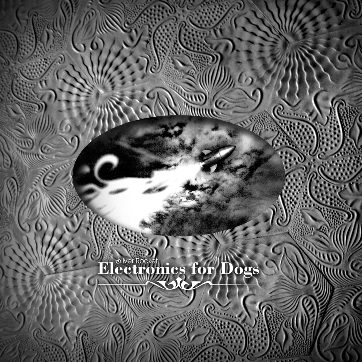 Electronics For Dogs album cover: a silver rocket in an embossed ornament